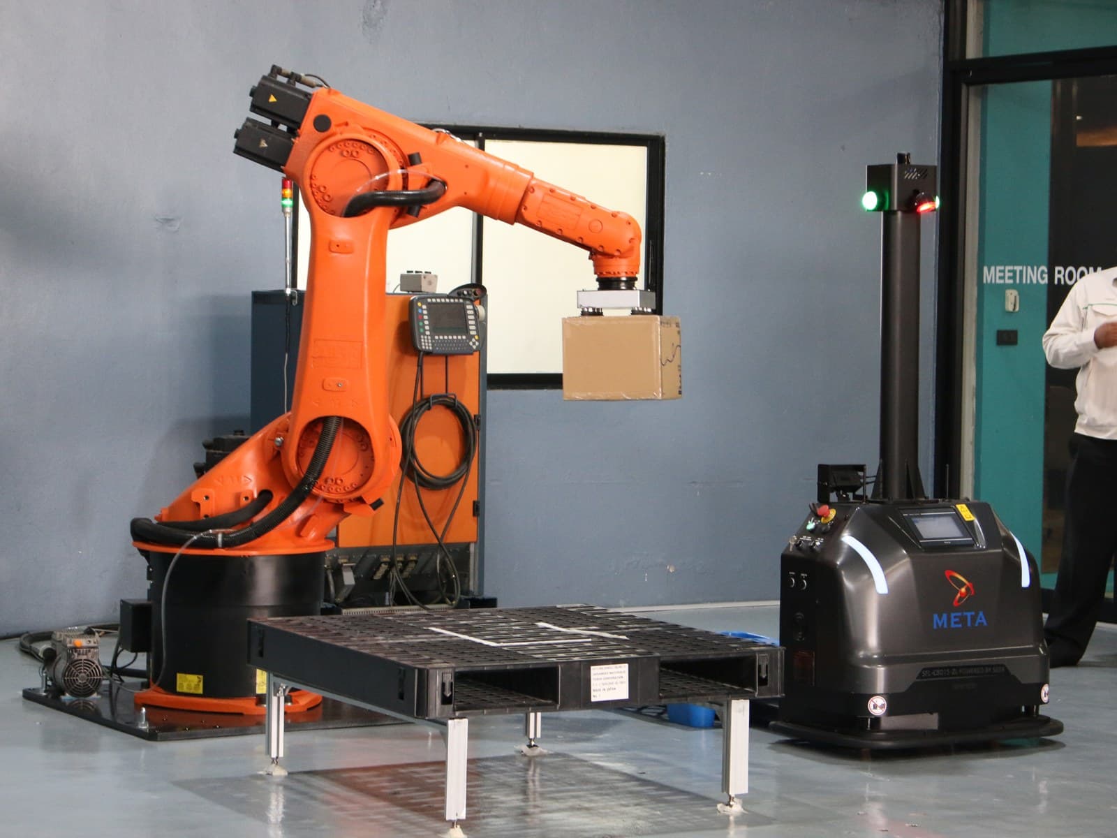 A robot arm and an AMR at a pallet station orchestrated by Nara
