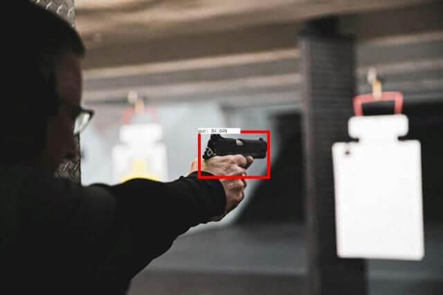 A person shooting a gun in a shooting range.